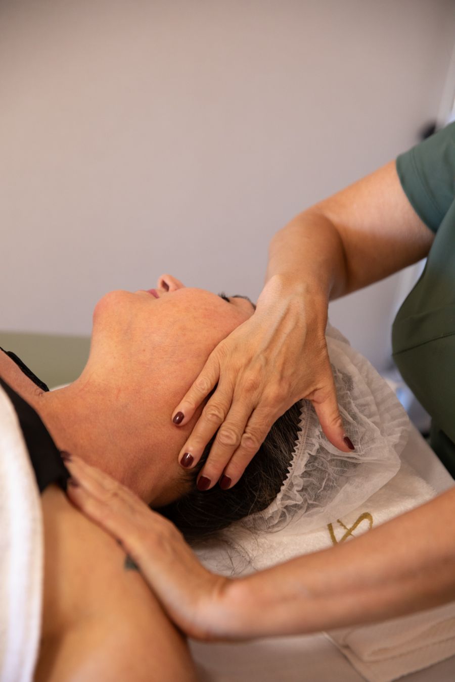 Fisioterapeuta em atendimento na região cervical de uma paciente